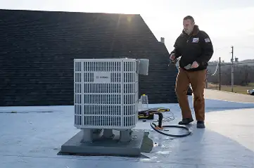 Vertex tech performing a rooftop AC repair in Ephrata as it gets dark outside