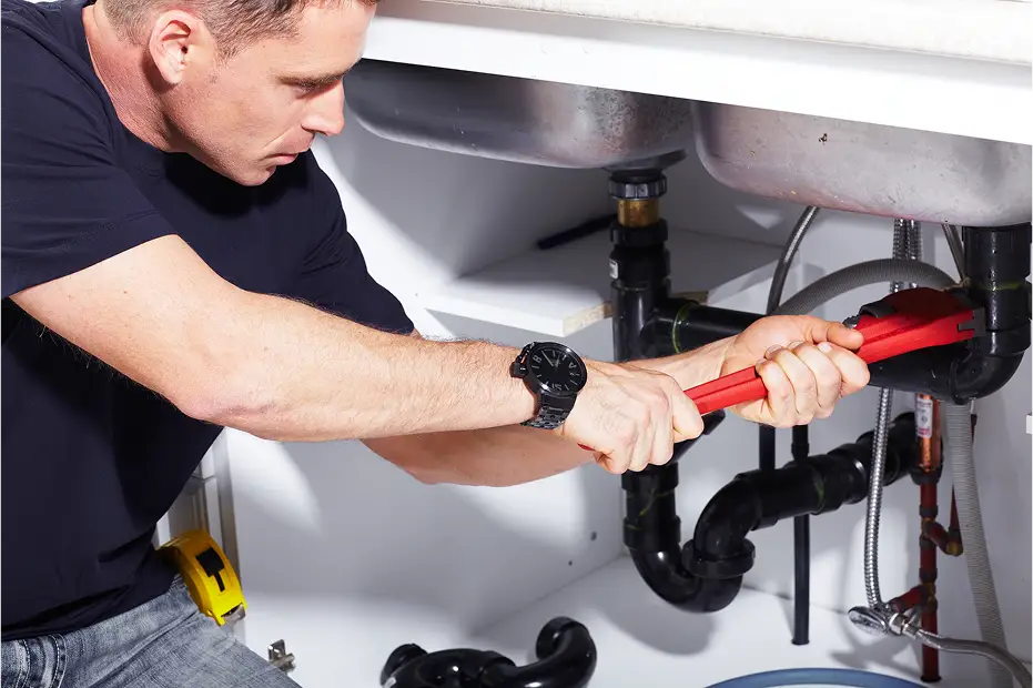 Ephrata plumber tightening a leaky sink pipe in Ephrata